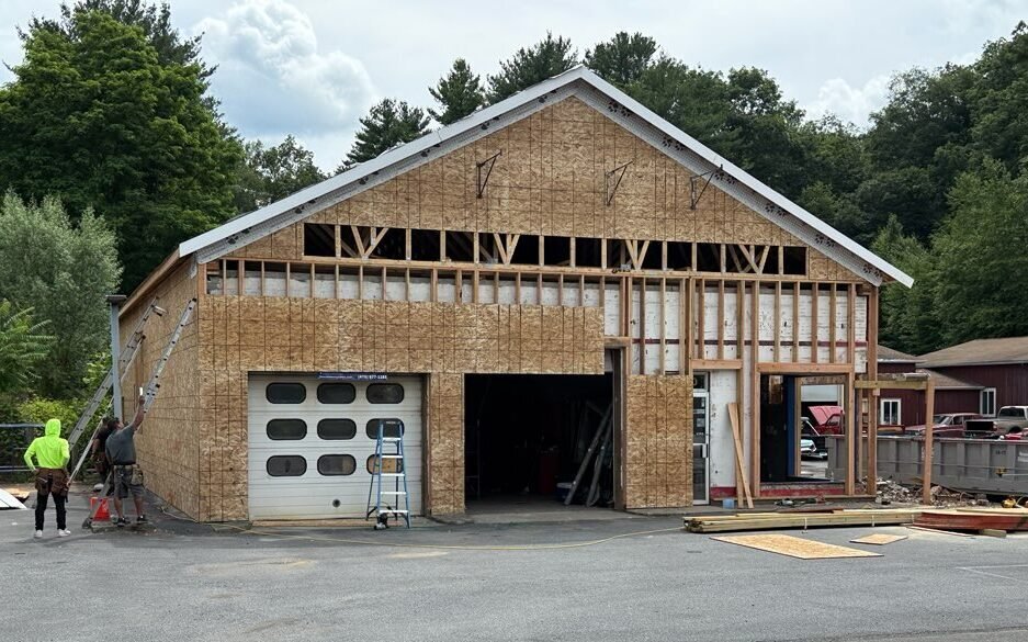 New framing and sheathing being installed across the garage frontage